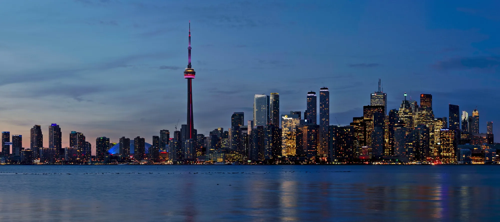The Toronto skyline and CN Tower at dusk, seen across the lake