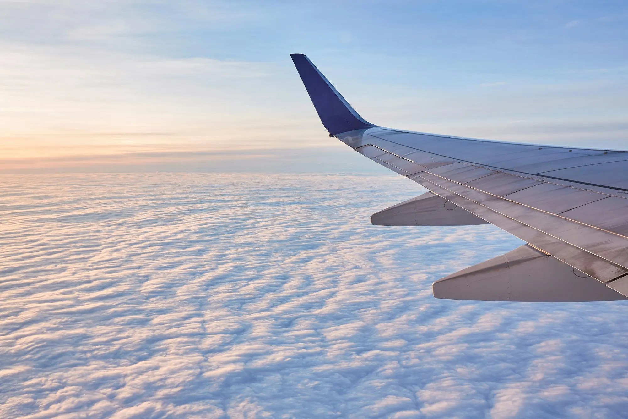 A widebody airliner silhouetted against a dusk sky